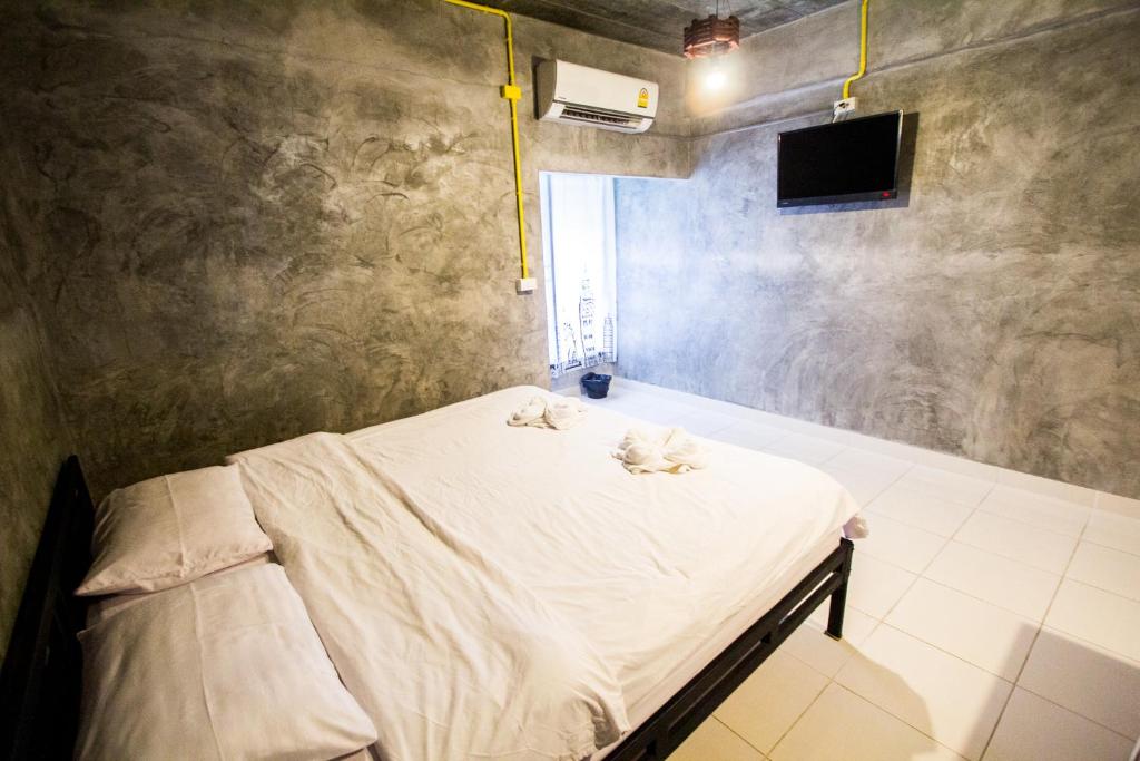 a bedroom with a bed with two cats on it at The Sky Loft Hotel in Pathum Thani