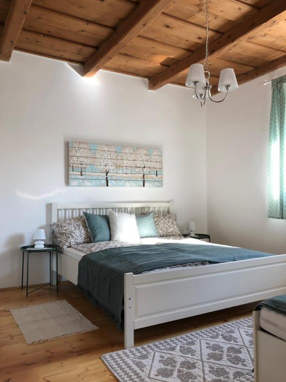 Un dormitorio con una cama grande en una habitación con techos de madera. en Twin Pines Apartment, en Egerszalók