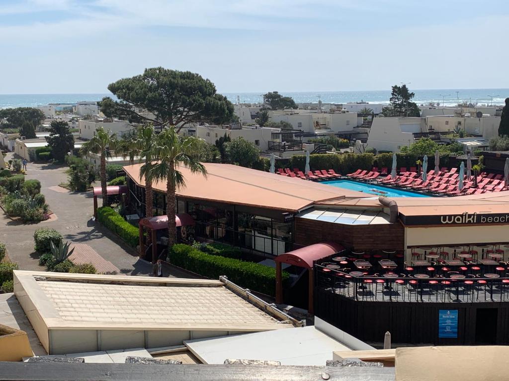 uma vista panorâmica de um resort com uma piscina e guarda-sóis em VILLAGE NATURISTE em Cap d'Agde