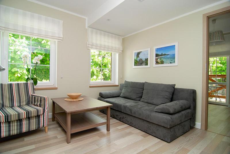 a living room with a couch and a table at Apartament Plaza in Rowy