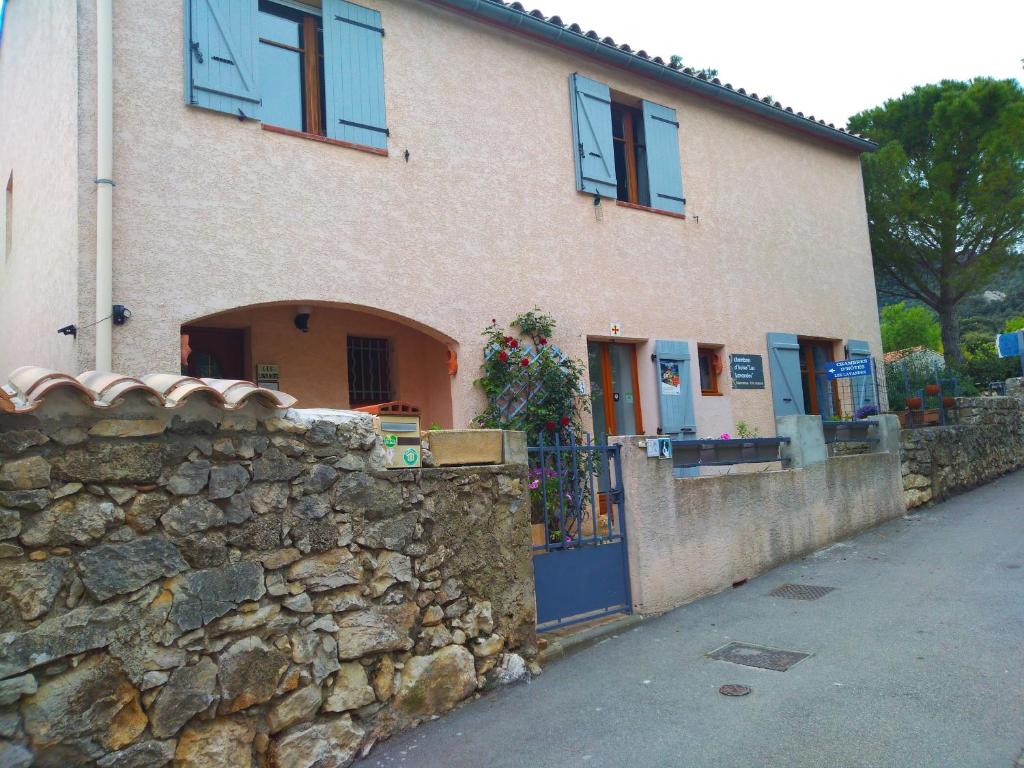 uma casa com uma parede de pedra e uma cerca de pedra em Les lavandes em Duilhac