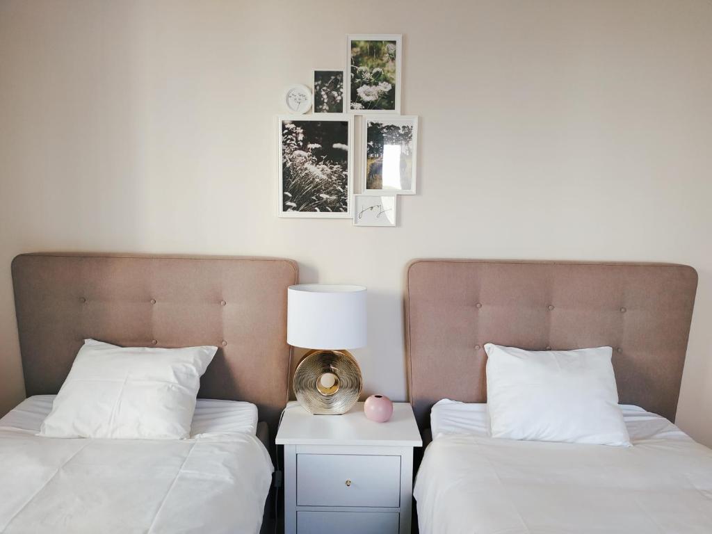 dwa łóżka z białą pościelą i lampką na stoliku nocnym w obiekcie Two-bedroom apartment 'Taupé' w Wiedniu