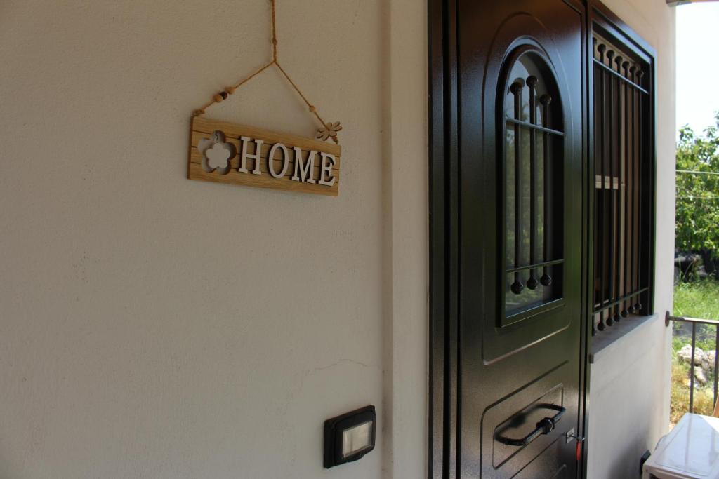 Znak z napisem "Dom na ścianie obok drzwi" w obiekcie Brigida's Apartments w mieście Ýpsos