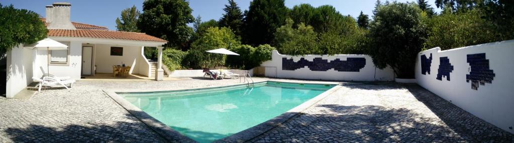 a swimming pool in the backyard of a house at Enjoy the best of countryside in Leiria