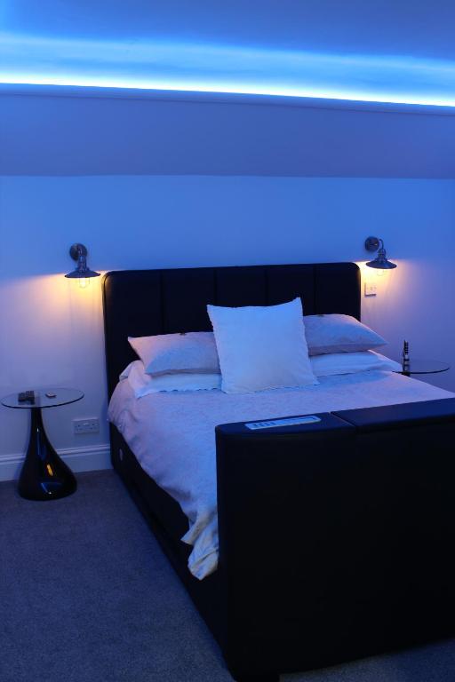 a bedroom with a bed with a blue light at Elysian Fields B&B in Helston
