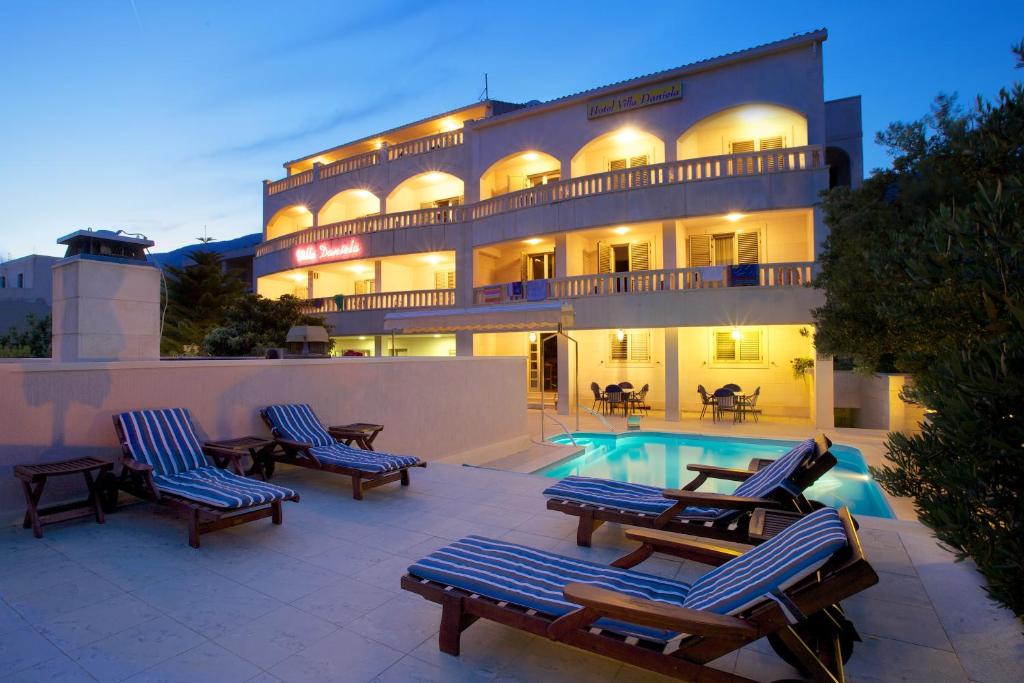 a hotel with lounge chairs and a swimming pool at Villa Daniela in Bol