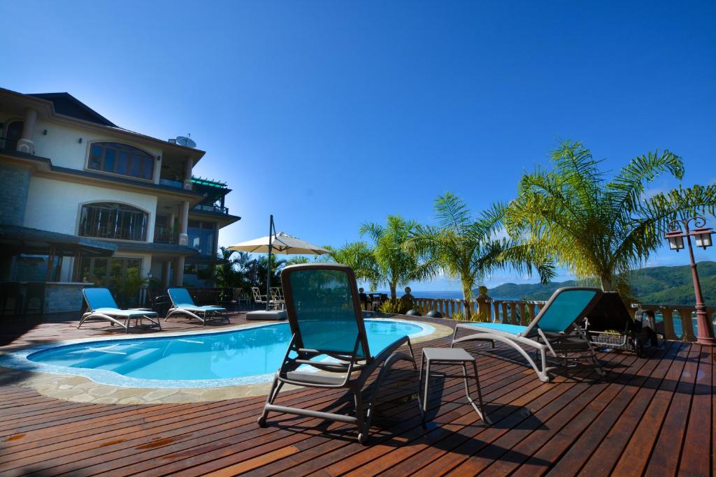 um grupo de cadeiras sentadas ao lado de uma piscina em Ocean Terrace em Anse Royale