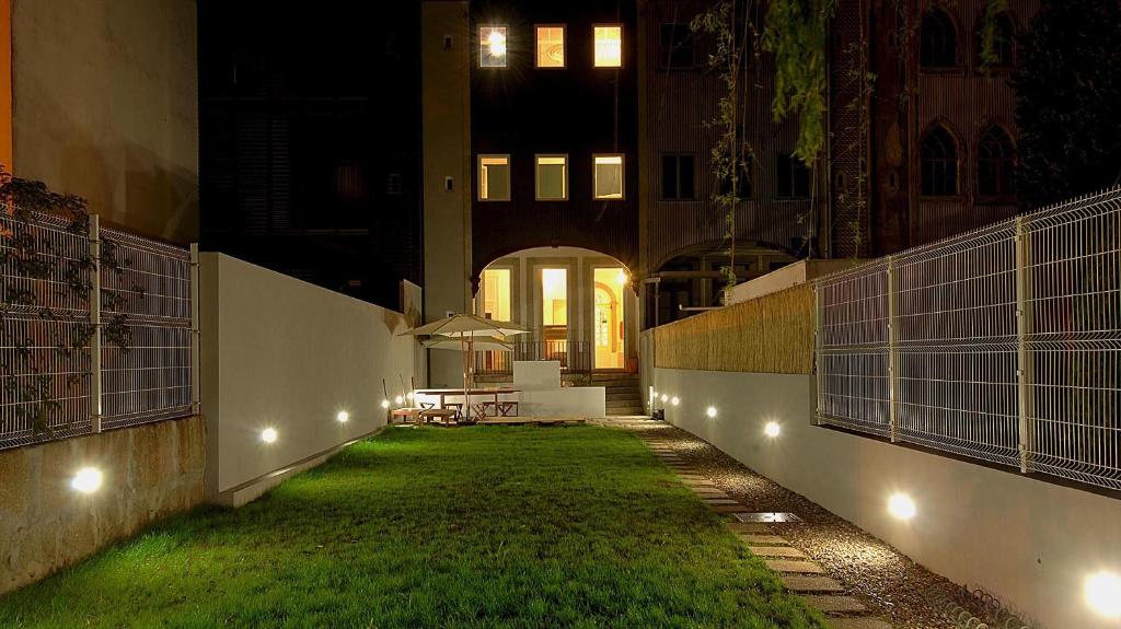 un edificio con un patio de césped y luces en So Cool Hostel Porto, en Oporto