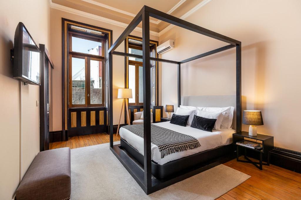 a bedroom with a four poster canopy bed at YOUROPO - Bolhao in Porto