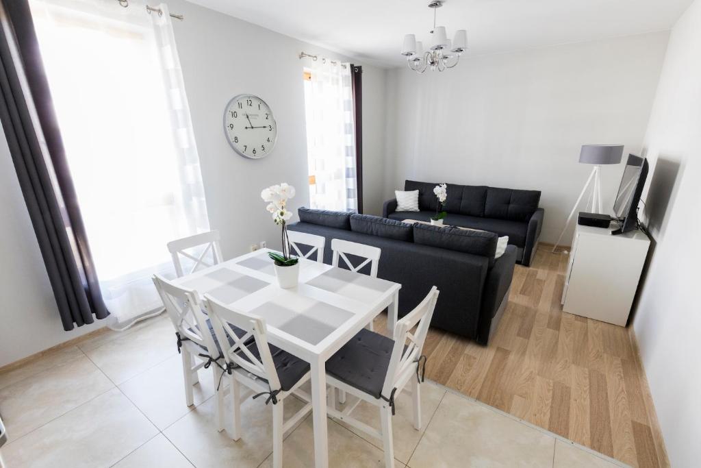 ein Wohnzimmer mit einem Tisch und einem Sofa in der Unterkunft Apartament 3d Szczecin in Stettin