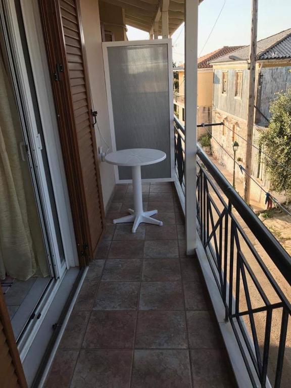 balkon z białym stołem na balkonie w obiekcie Nonika’s house 1 w mieście Tsoukalades