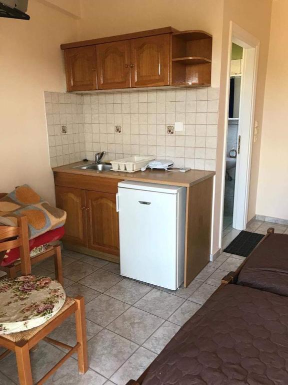 kuchnia z białą lodówką i drewnianymi szafkami w obiekcie Nonika’s house 1 w mieście Tsoukalades