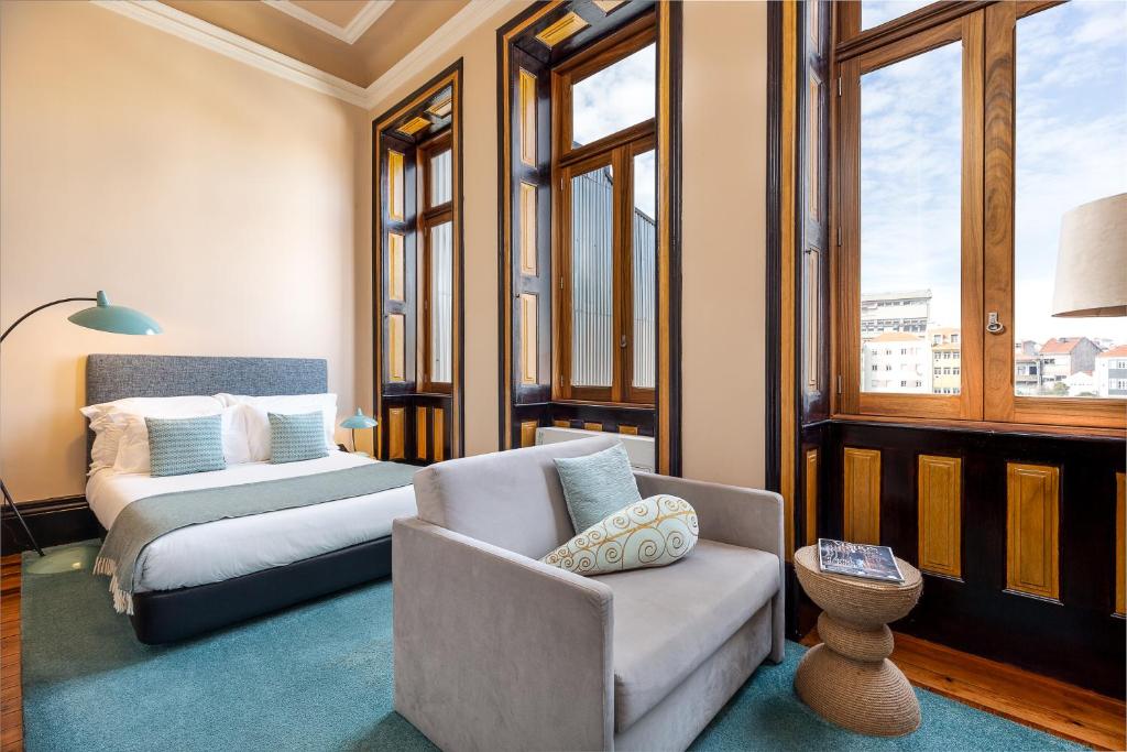 een kamer met een bed, een bank en een stoel bij YOUROPO - Bolhao in Porto