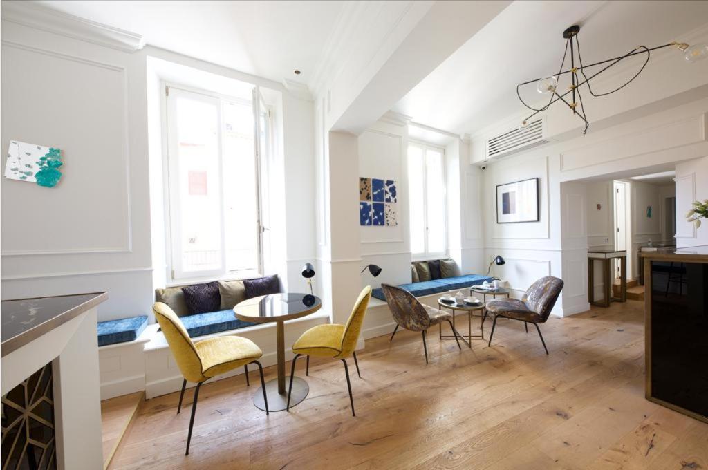 uma sala de estar com um sofá, uma mesa e cadeiras em Parisii Luxury Relais Rome em Roma