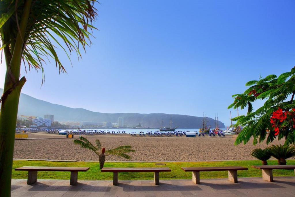 a group of benches on a beach near a beach at Royal Stylish sea view in Los Cristianos