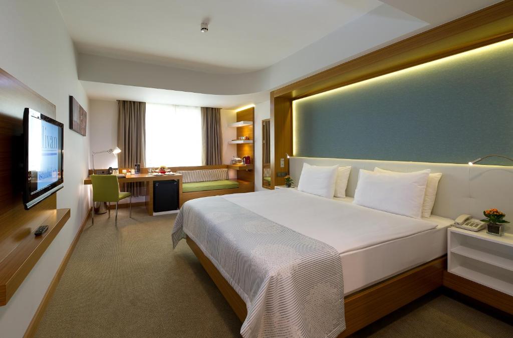 a hotel room with a large bed and a desk at Divan Istanbul City in Istanbul