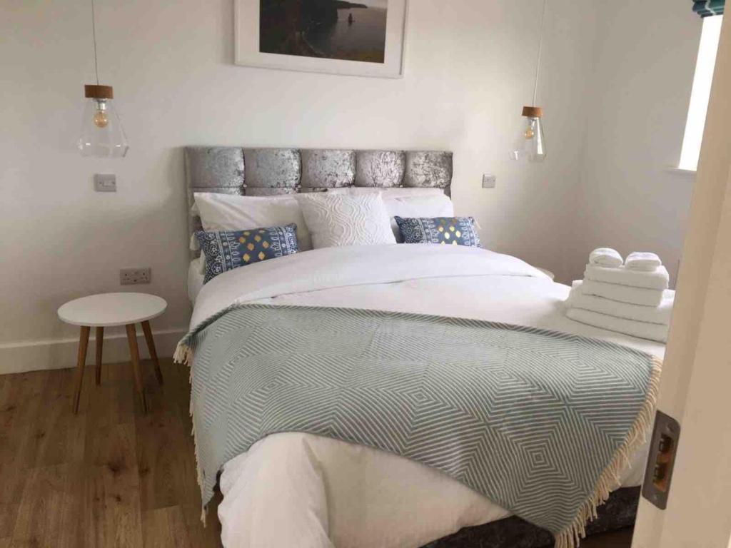 a bedroom with a large bed and a table at Boherbui Cottage on the Wild Atlantic Way in Doolin