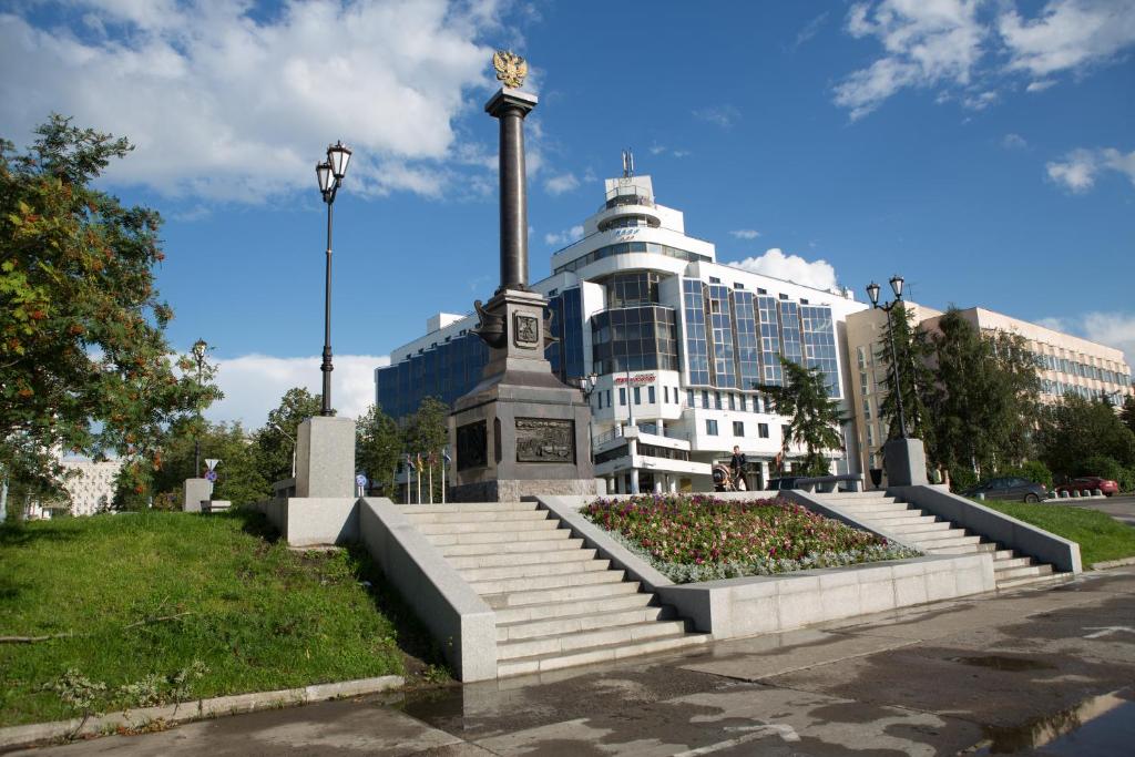 a large building with a statue in front of it at Pur-Navolok Hotel in Arkhangelsk