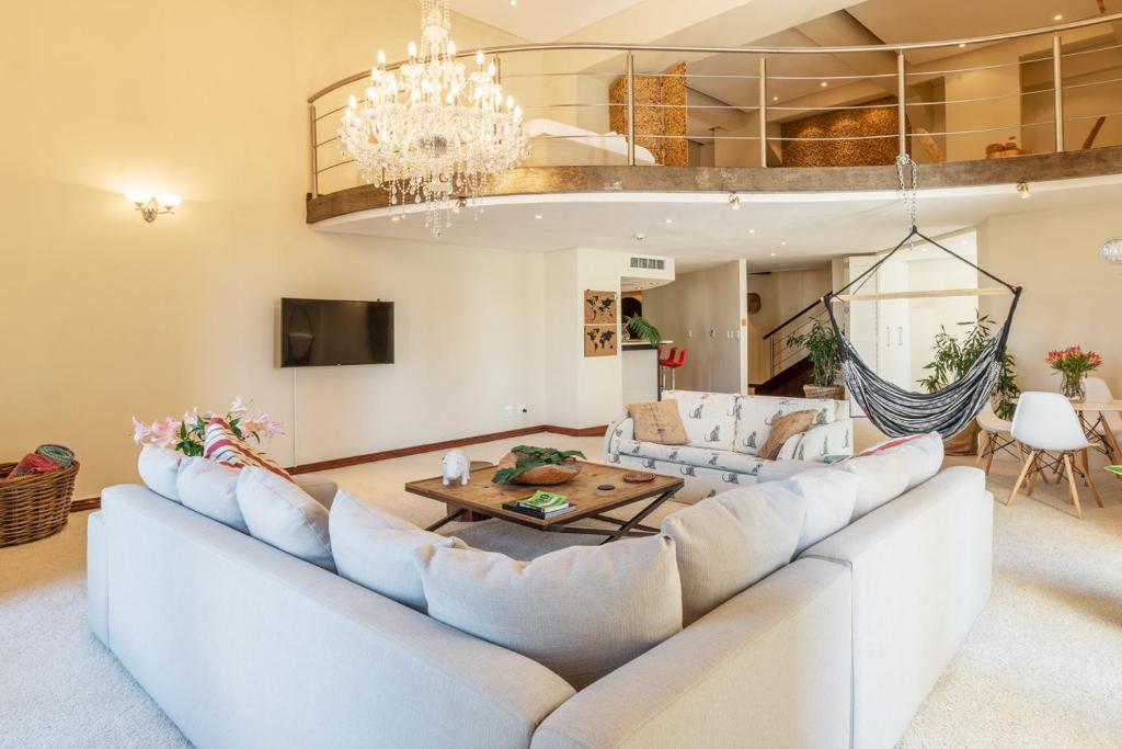 a living room with a large couch and a chandelier at NYC Style Downtown Duplex in Cape Town