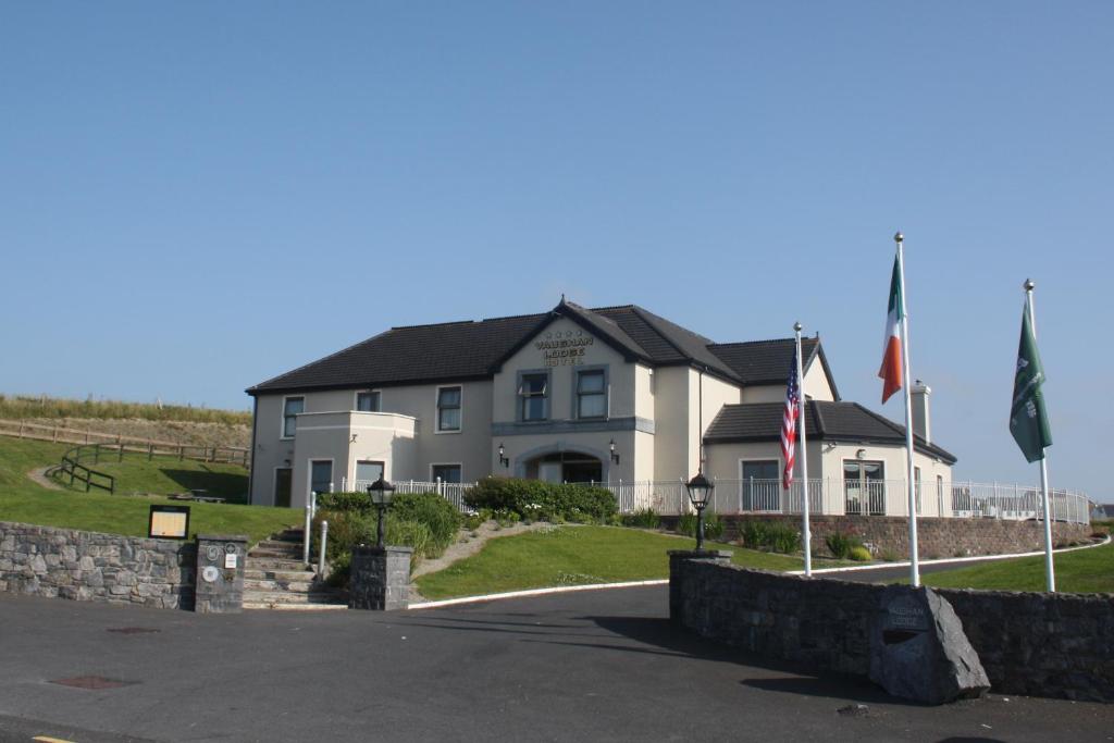 a large house with two flags in front of it at Vaughan Lodge Hotel in Lahinch