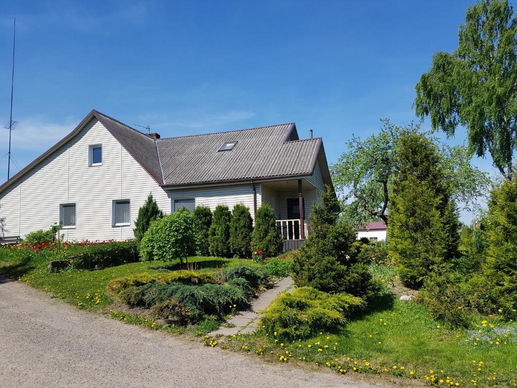 uma casa branca com um jardim em frente em Česlovos sodyba em Zarasai