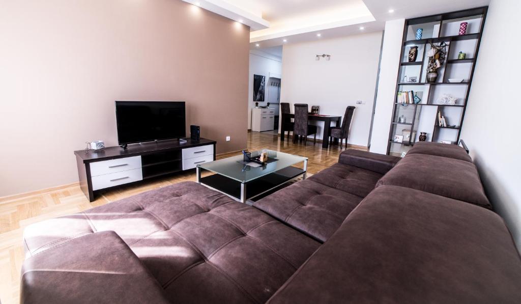 ein Wohnzimmer mit einem braunen Sofa und einem TV in der Unterkunft Premium 1 apartments in Aranđelovac