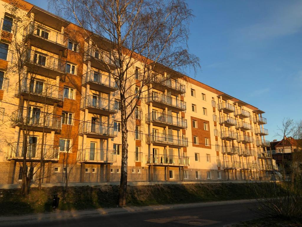 un edificio de apartamentos con balcones en el lateral de una calle en Apartament nad jeziorem, en Olsztyn