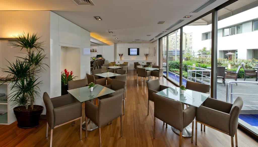 a restaurant with tables and chairs and windows at Divan Istanbul City in Istanbul