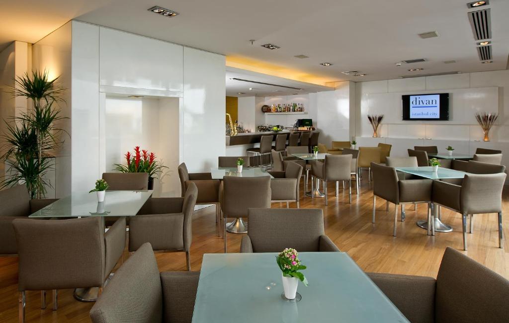 a restaurant with tables and chairs and a bar at Divan Istanbul City in Istanbul