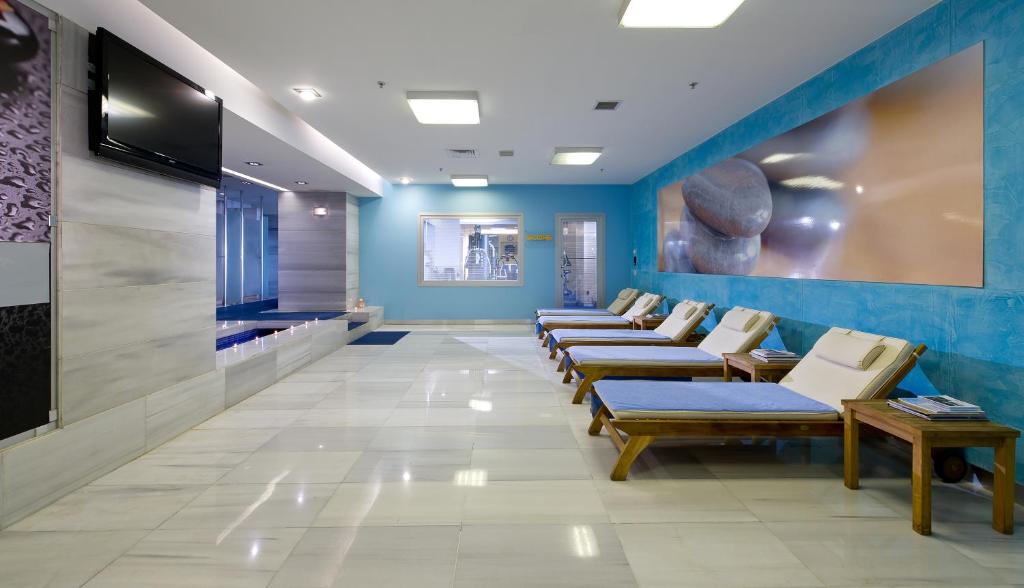 a waiting room with a row of chairs and a tv at Divan Istanbul City in Istanbul