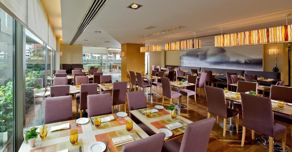 a restaurant with tables and chairs in a room at Divan Istanbul City in Istanbul