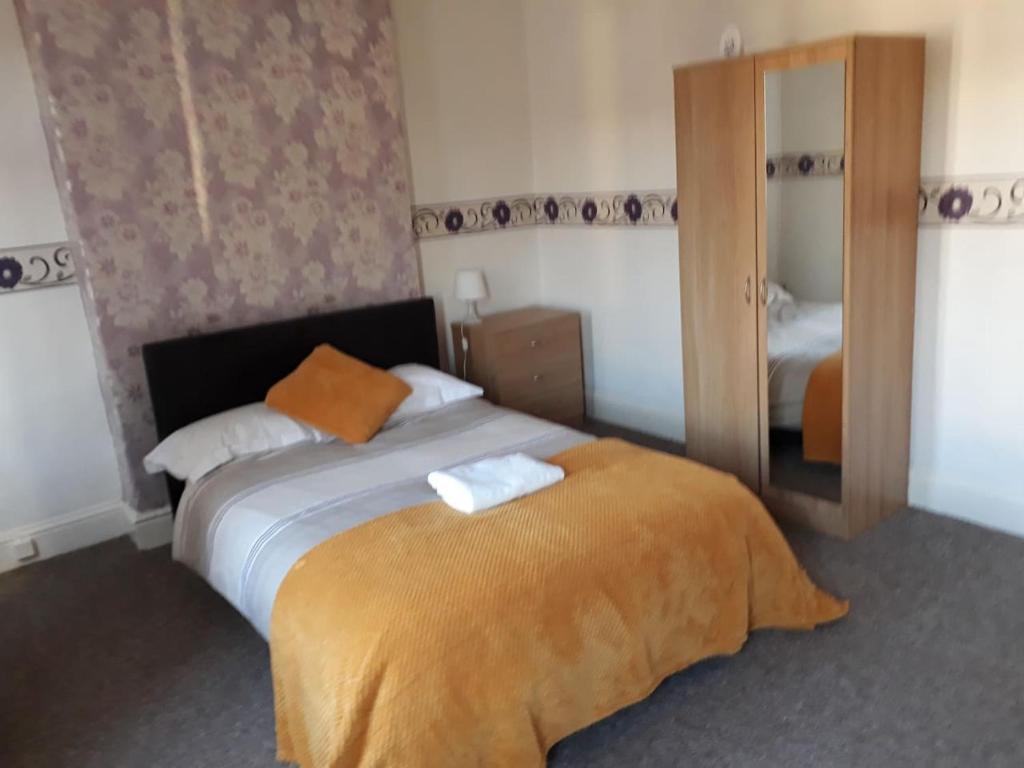 um quarto de hotel com uma cama e um espelho em Villa Parrin em Manchester