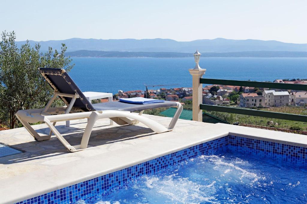 a lounge chair sitting next to a swimming pool at Holiday home Nina in Bol