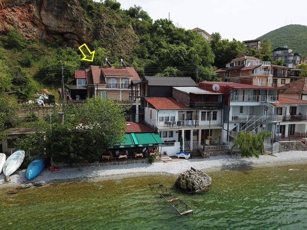 um grupo de casas na costa de uma massa de água em Villa Gjorgi em Ohrid