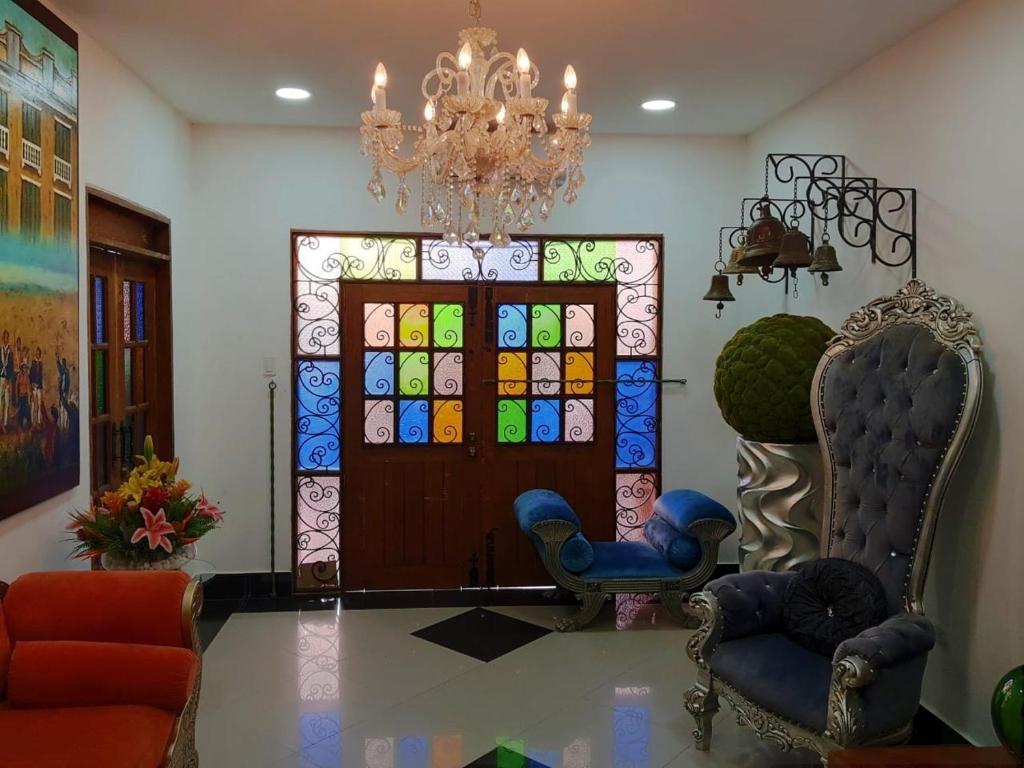 Habitación con 2 sillas y puerta con lámpara de araña. en Hotel Boutique Campanario del Río, en Soledad