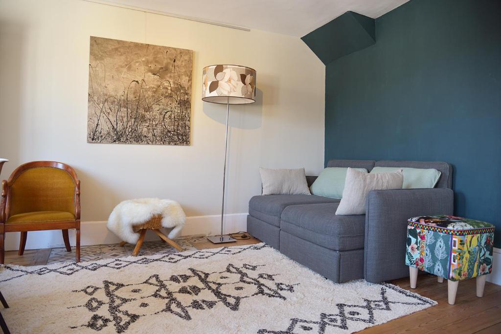 sala de estar con sofá azul y lámpara en Gîte de l'Écu, en La Roche-Guyon