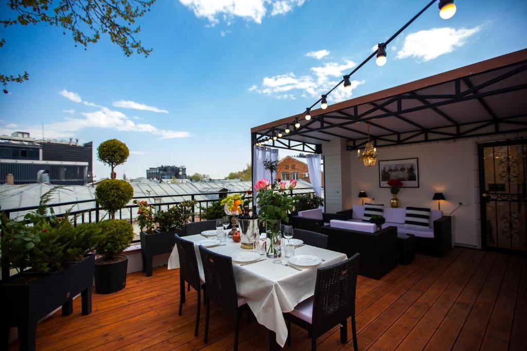 a restaurant with tables and chairs on a deck at Presidential Suite Prince Machabeli in Tbilisi City