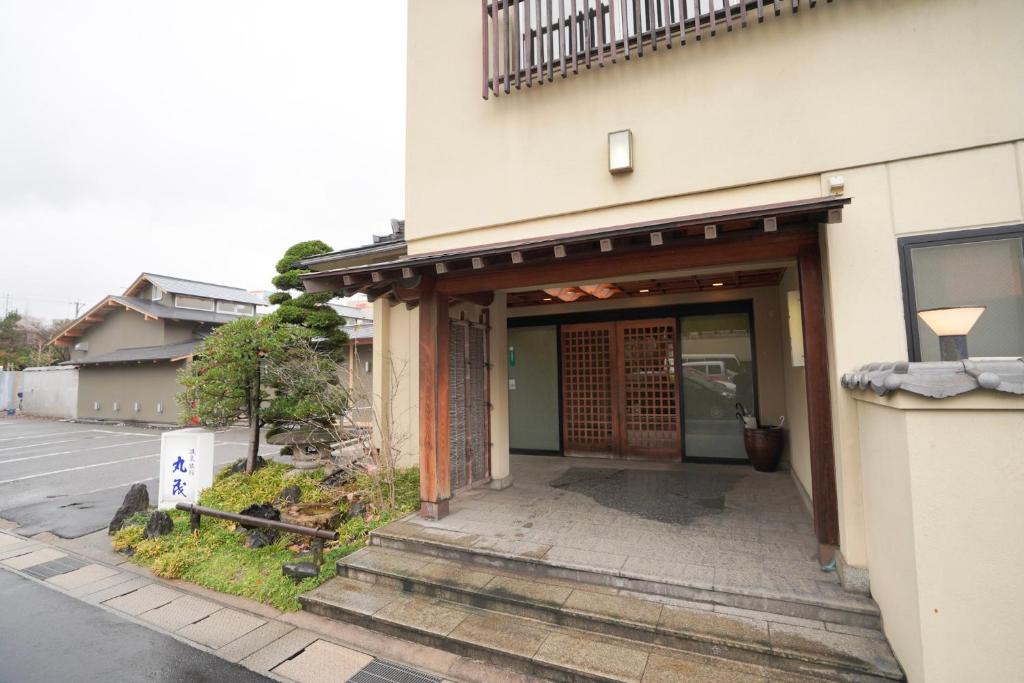 un accès à un bâtiment avec une porte dans l'établissement Ryokan Marumo, à Tottori