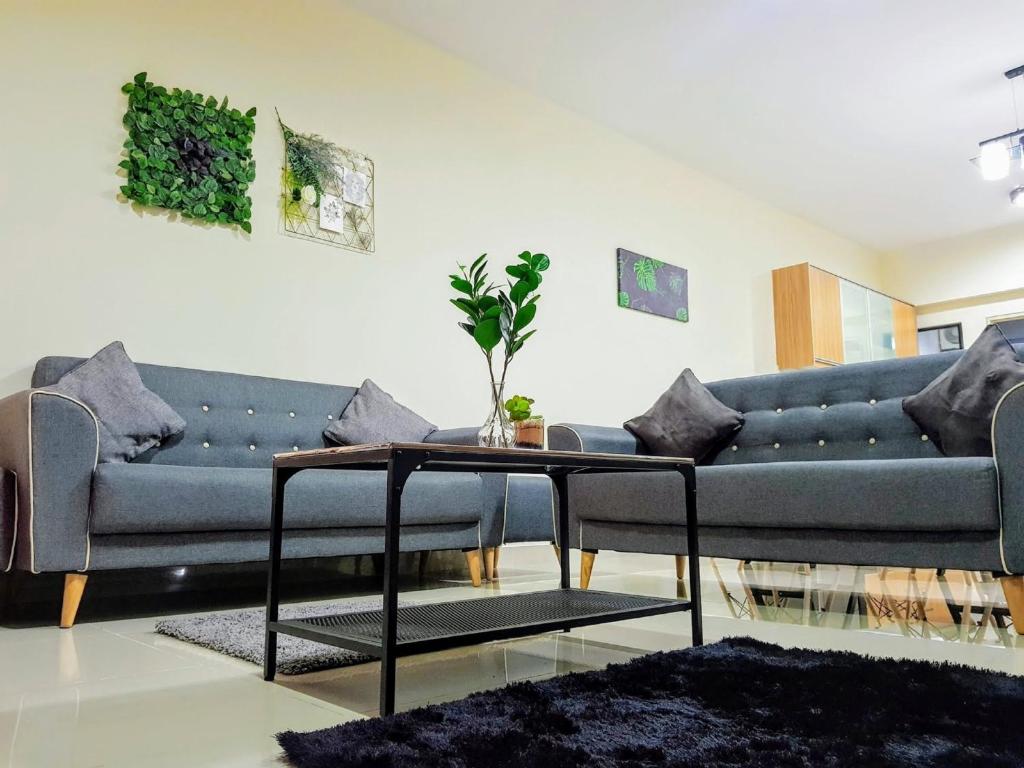 a living room with a blue couch and a table at Puchong Setiawalk 8-12 pax 5min LRT Cozy Apartment in Puchong