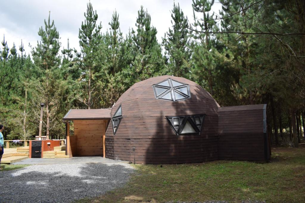 una gran casa cúpula de madera en un patio en Domos Nelkewue en Santa Bárbara
