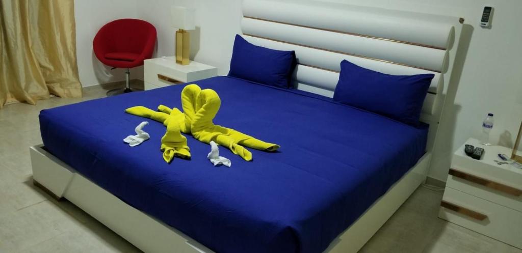 un animal de peluche amarillo sobre una cama en Villa de Colores 3 Rooms 5 king Beds, en Sosúa
