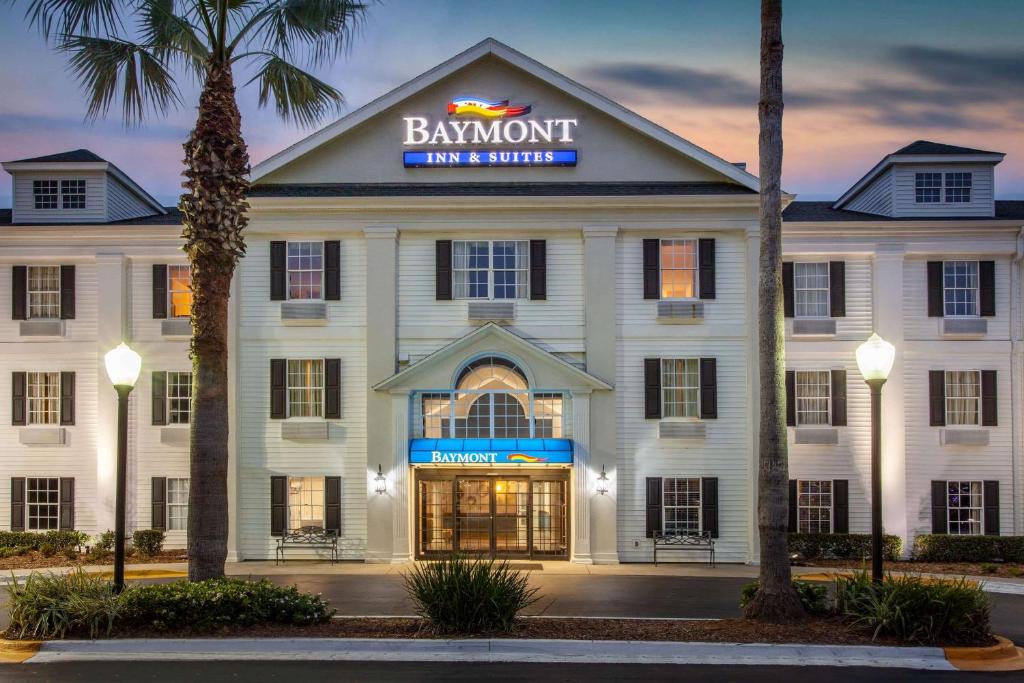 Ein weißes Gebäude mit einem Schild, das Bankett Inn und Suite liest in der Unterkunft Baymont by Wyndham Jacksonville/Butler Blvd in Jacksonville