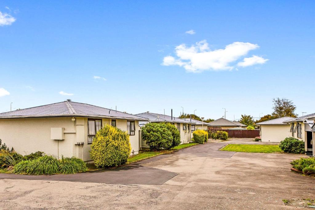 eine Reihe von Häusern auf einer Straße mit Auffahrt in der Unterkunft Econo Lodge Canterbury Court Motel in Christchurch