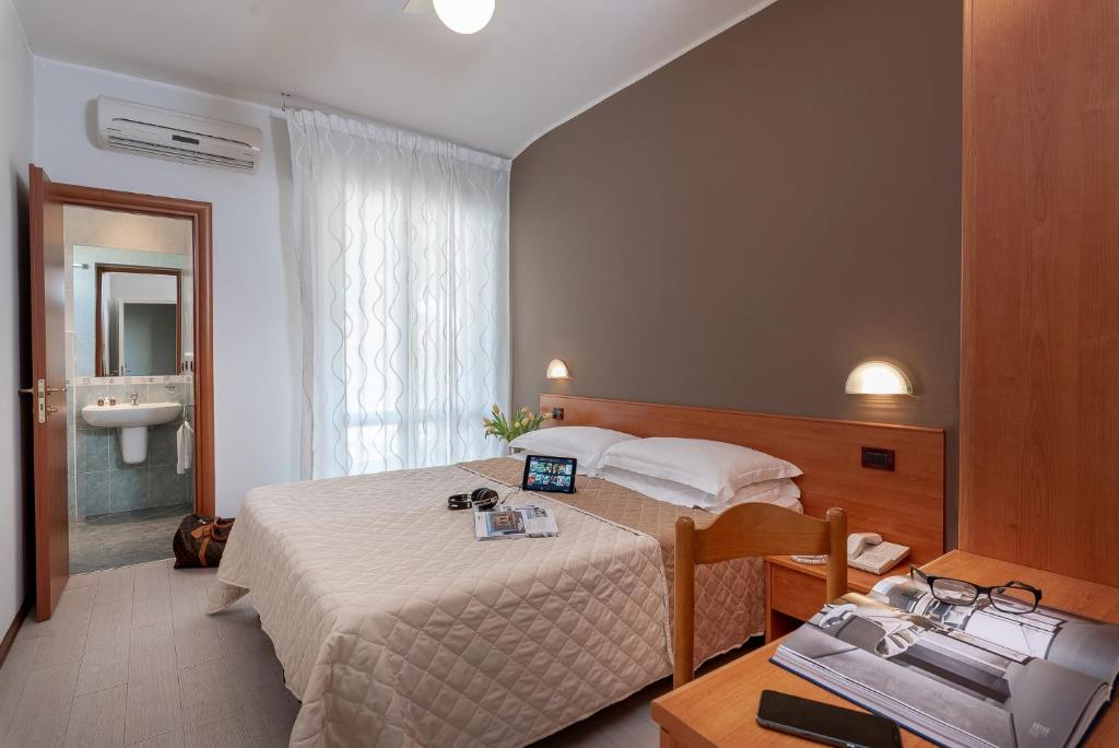 Habitación de hotel con cama y escritorio con ordenador portátil. en Hotel Pierre, en Riccione