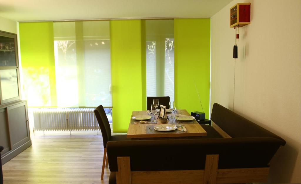 une salle à manger avec une table et des murs verts dans l'établissement Waldblick, à Obertal