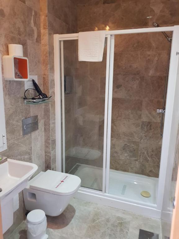 a bathroom with a shower and a toilet and a sink at Hotel Senderos in Agua Amarga
