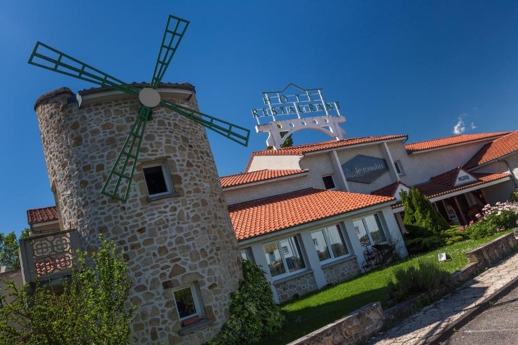 ein Haus mit einer Windmühle davor in der Unterkunft LOGIS Hôtel Le Moulin Des Gardelles in Riom