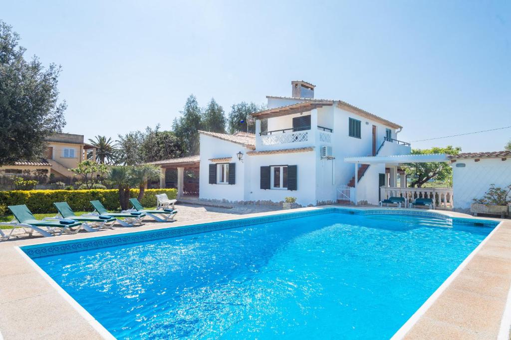 a villa with a swimming pool in front of a house at Villa Volentina in Port de Pollensa