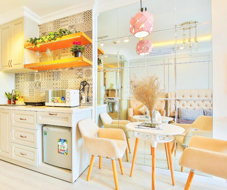 uma cozinha e sala de jantar com mesa e cadeiras em Go Sweet House - Rivergate Residence em Ho Chi Minh