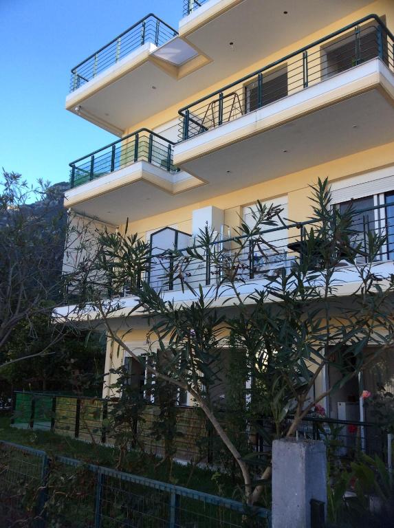 a building with a tree in front of it at Ourania's Apartments in Kamena Vourla